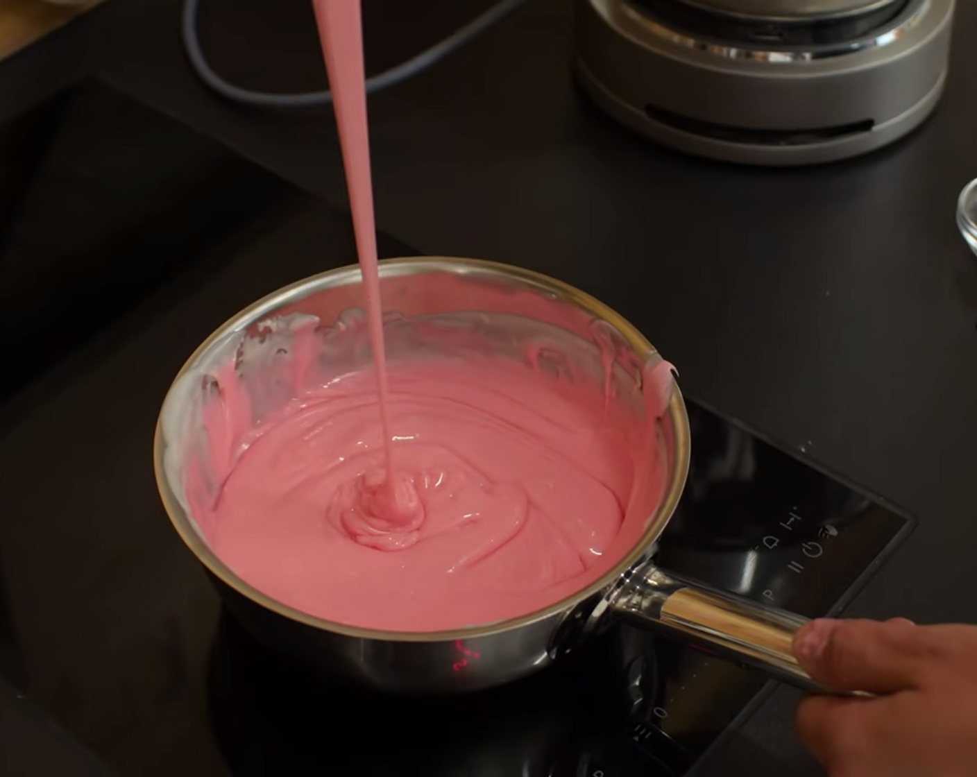 Schritt 13 Zum Schluss noch ein wenig rote Lebensmittelfarbe dazugeben, um eine rosa Glasur zu bekommen. Die Farbe streifenfrei daruntermischen und dann den Topf vom Herd nehmen.