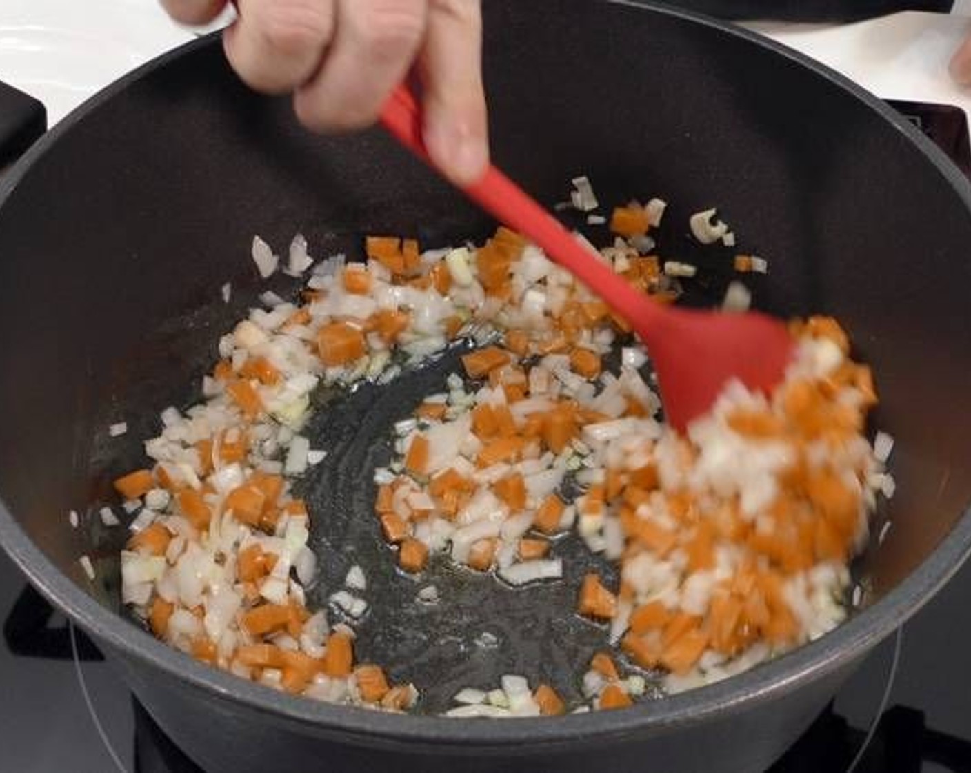 Schritt 1 Knoblauch (4 Zehen), geschnittene Zwiebel (1) und geschnittene Karotten (2) in einen grossen Topf geben und in so viel Olivenöl (wenig) anbraten, dass der Boden der Pfanne bedeckt ist. Mit Salz (wenig) würzen.