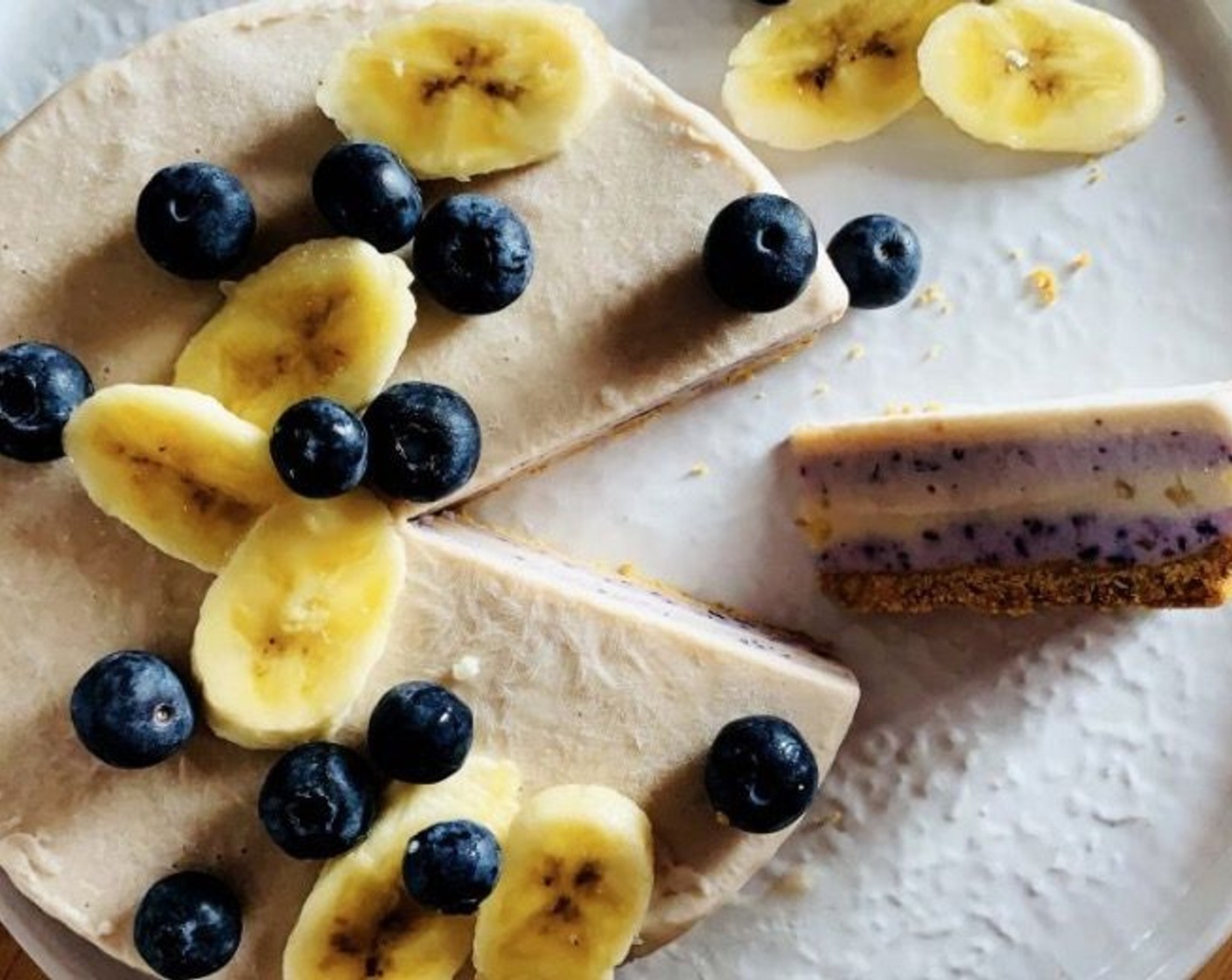 Schritt 12 Den Kuchen mit den restlichen Bananenscheiben (1) belegen und Limettensaft (1/2) beträufeln, um das Braunwerden zu vermeiden. Mit frischen Blaubeeren garnieren. Sofort servieren und geniessen!