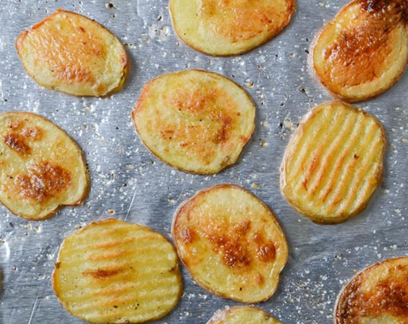 Schritt 5 Aus dem Ofen nehmen und die Kartoffeln umdrehen. Das Backblech wieder in den Ofen schieben und weitere 10-12 Minuten backen, bis die Kartoffeln golden und knusprig sind. Aus dem Ofen nehmen und beiseite stellen.