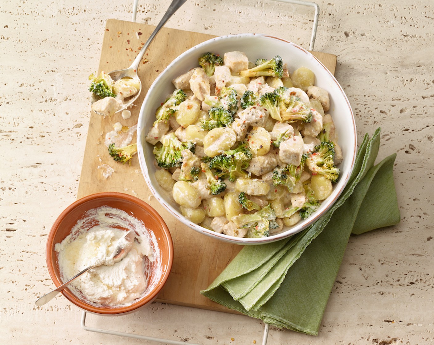 Schritt 8 Die Gnocchi abschütten und sofort mit der Poulet-Broccoli-Sauce mischen. In vorgewärmten tiefen Tellern anrichten und mit geriebenem Sbrinz (50 g) bestreuen.