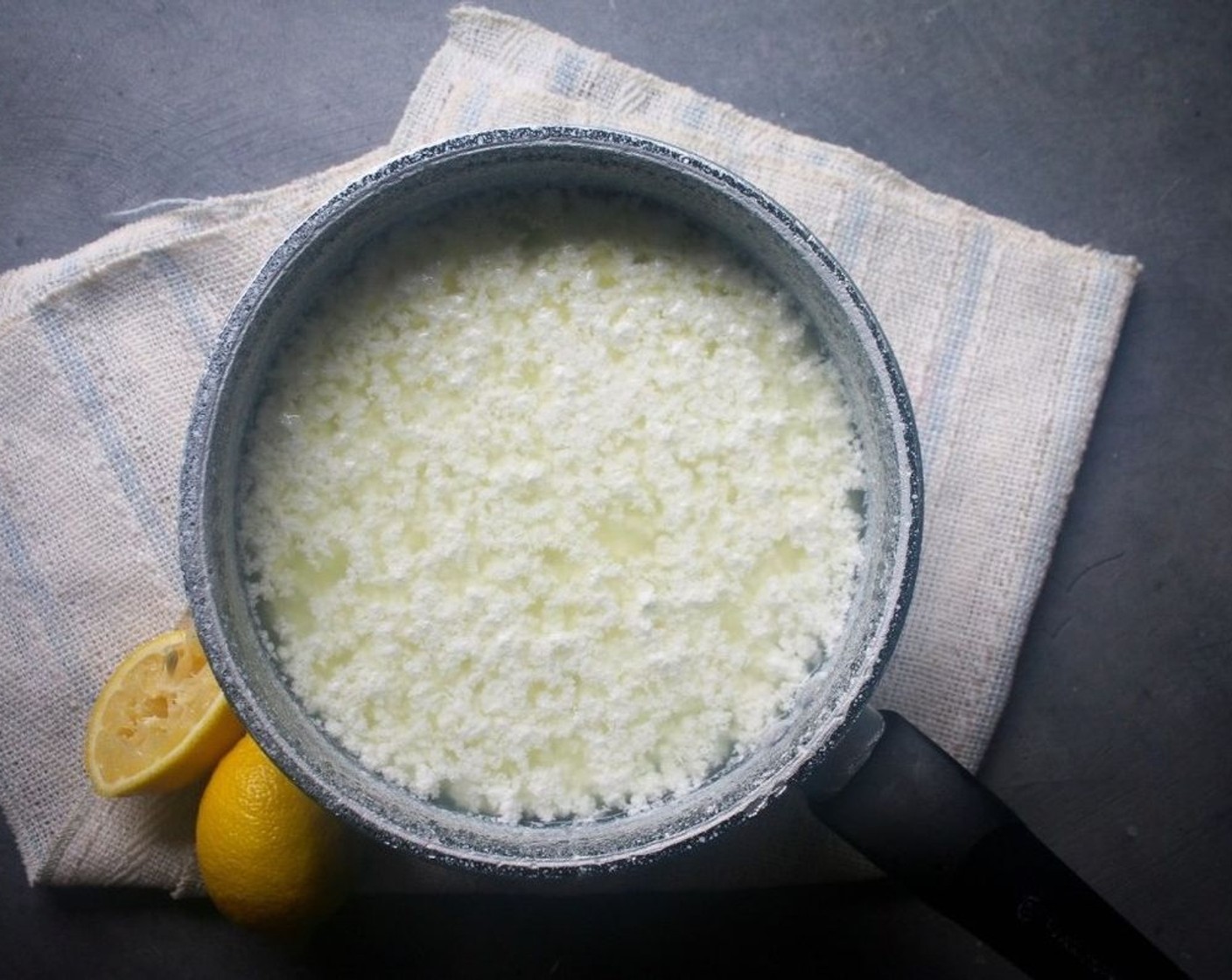 Schritt 2 Nach 10 Minuten sollten sich Käse und Molke in eine klare, gelbliche Flüssigkeit und weissen Käse trennen. Wenn das nicht der Fall ist, einen weiteren Esslöffel Zitronensaft hinzufügen und umrühren.
