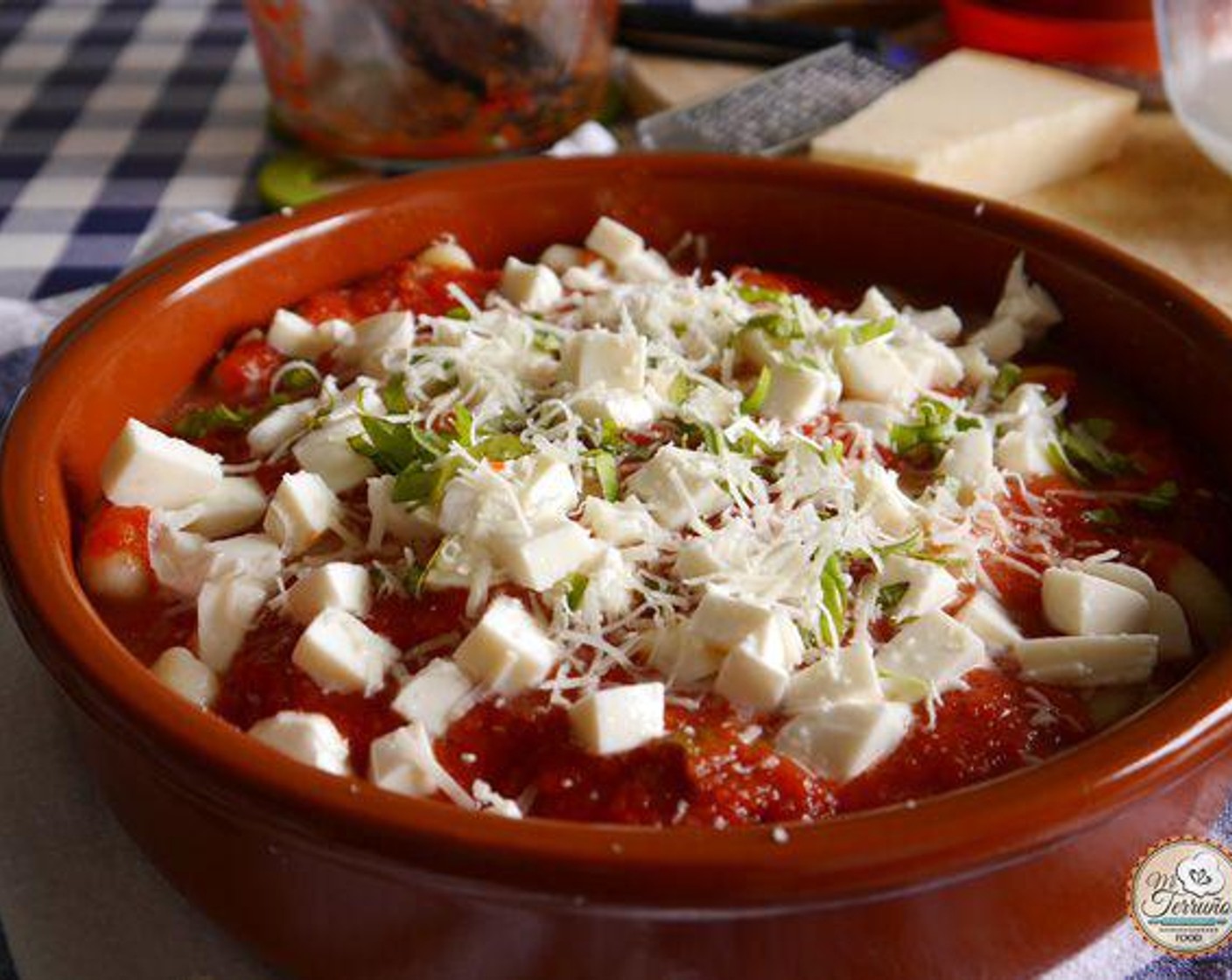 Schritt 4 In einer Auflaufform erst eine Schicht Tomatensauce (435 g) dann eine Schicht Gnocchi, eine Schicht Mozzarella, gehackten Basilikum (wenig), Salz (wenig), Pfeffer (wenig), Knoblauch (2 Zehen) und etwas geriebenen Parmigiano (200 g) geben.