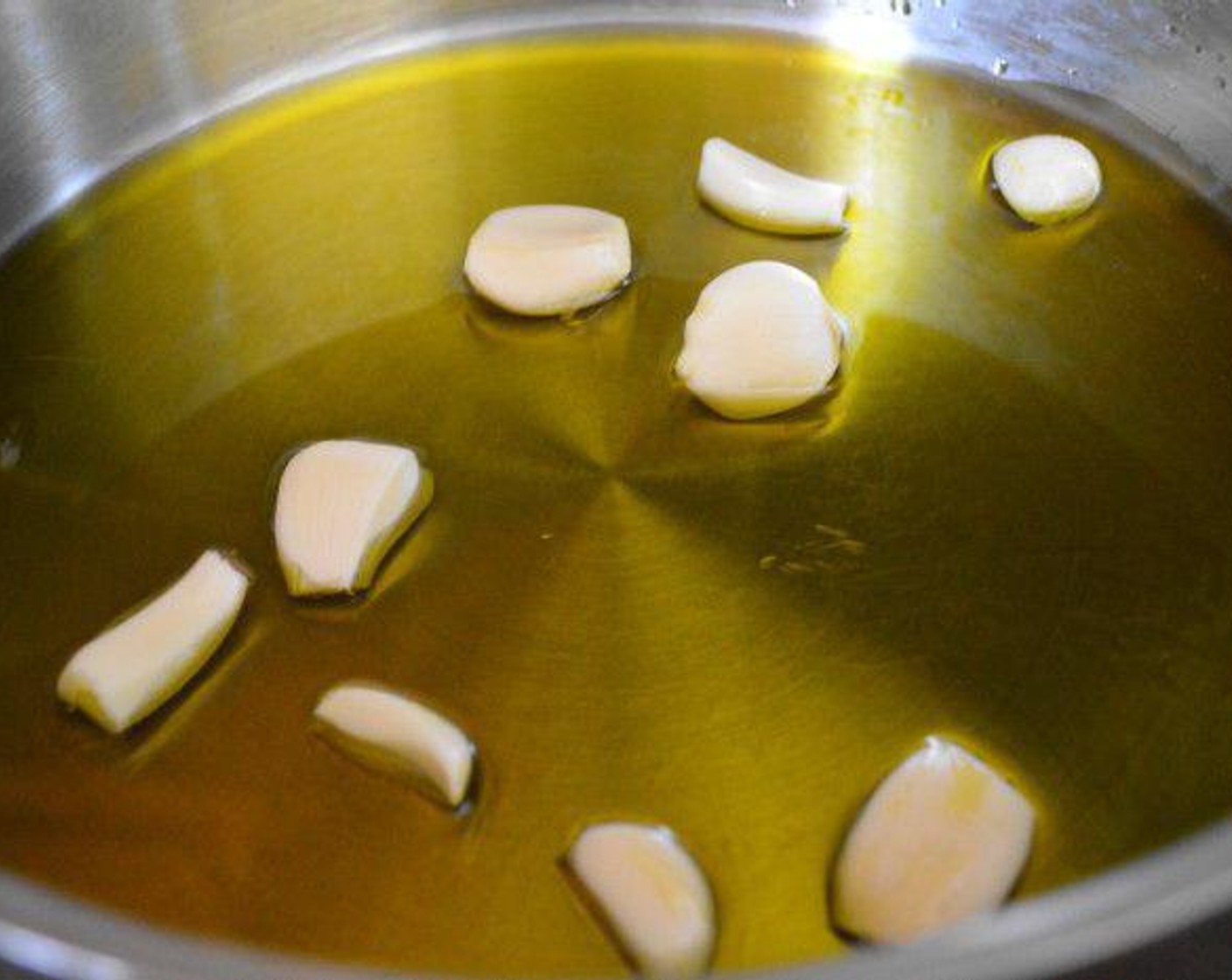 Schritt 1 In einer grossen Pfanne Olivenöl (240 ml) bei mittlerer bis hoher Hitze erhitzen. Geschälte Knoblauchzehen (10 Zehen) hinzugeben und etwa 1 Minute goldgelb braten. Dann die Hitze reduzieren und Weisswein (2 Esslöffel), Chiliflocken (2 Prisen) und Salz (2 Prisen) hinzugeben. Alles etwa 15 Minuten leicht köcheln lassen.
