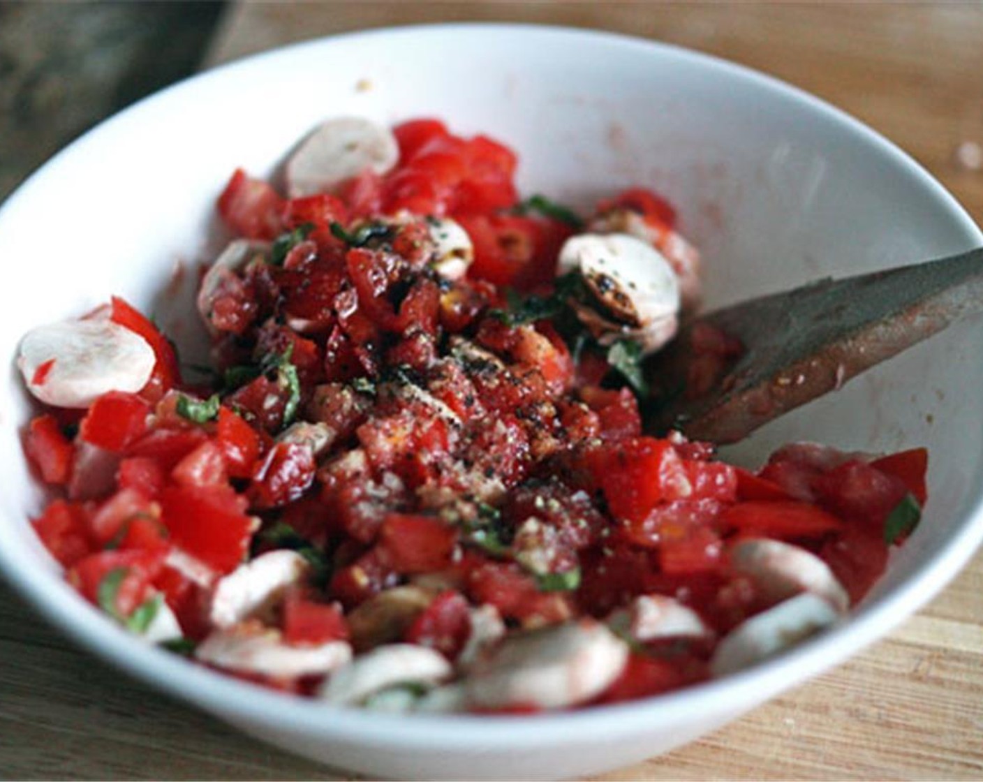 Schritt 4 Tomate, Mozzarella und Basilikum mit in die Schüssel geben. Essig (1 EL), Salz (nach Bedarf) und Pfeffer (nach Bedarf) hinzufügen und gut verrühren. Beiseitestellen, während das Brot zubereitet wird.