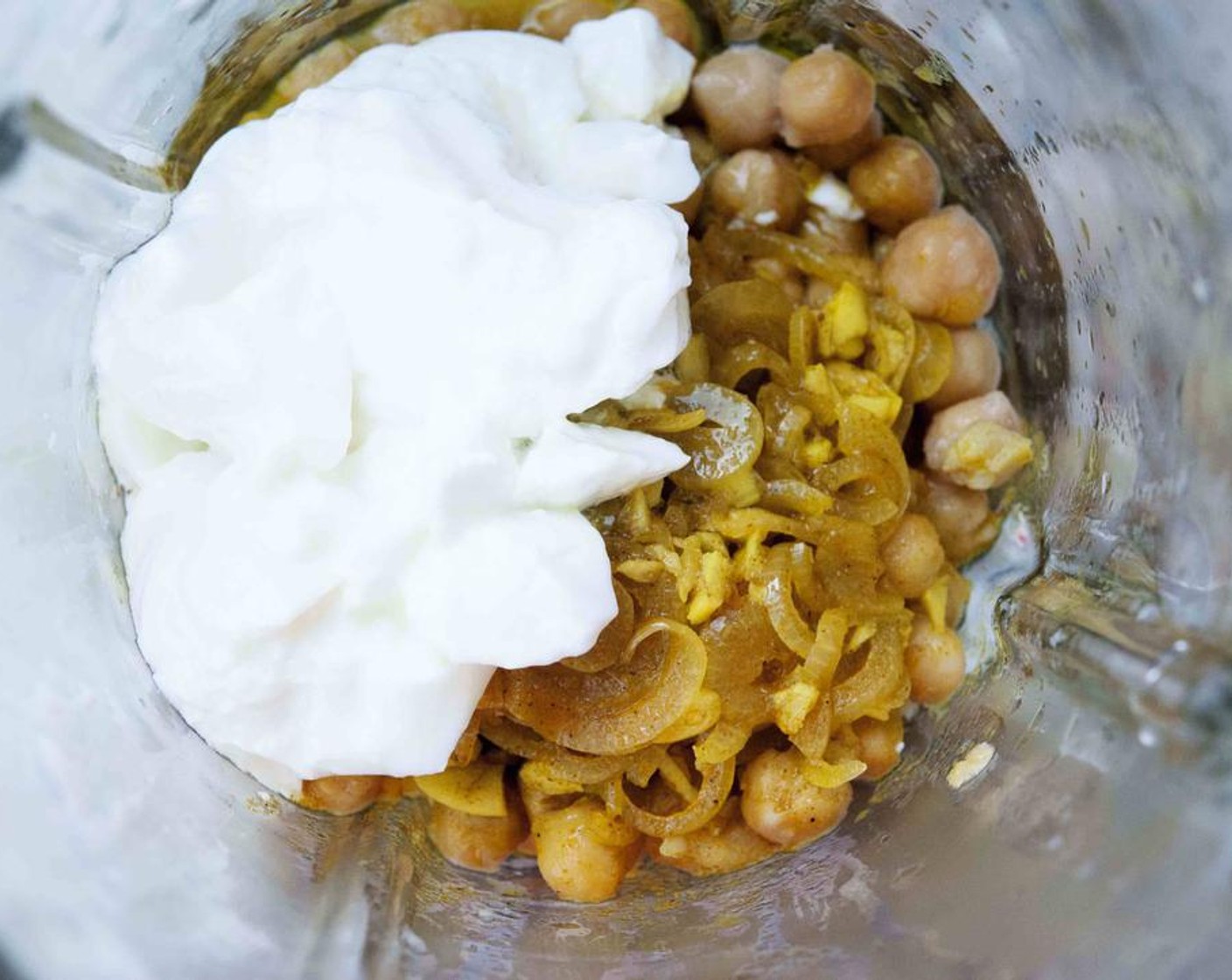 Schritt 3 In einen Mixer oder eine Küchenmaschine Kichererbsen (300 g), Joghurt (120 g), Zwiebel und Knoblauch, Limettensaft (1), sowie Salz (wenig) und Pfeffer (wenig) geben.