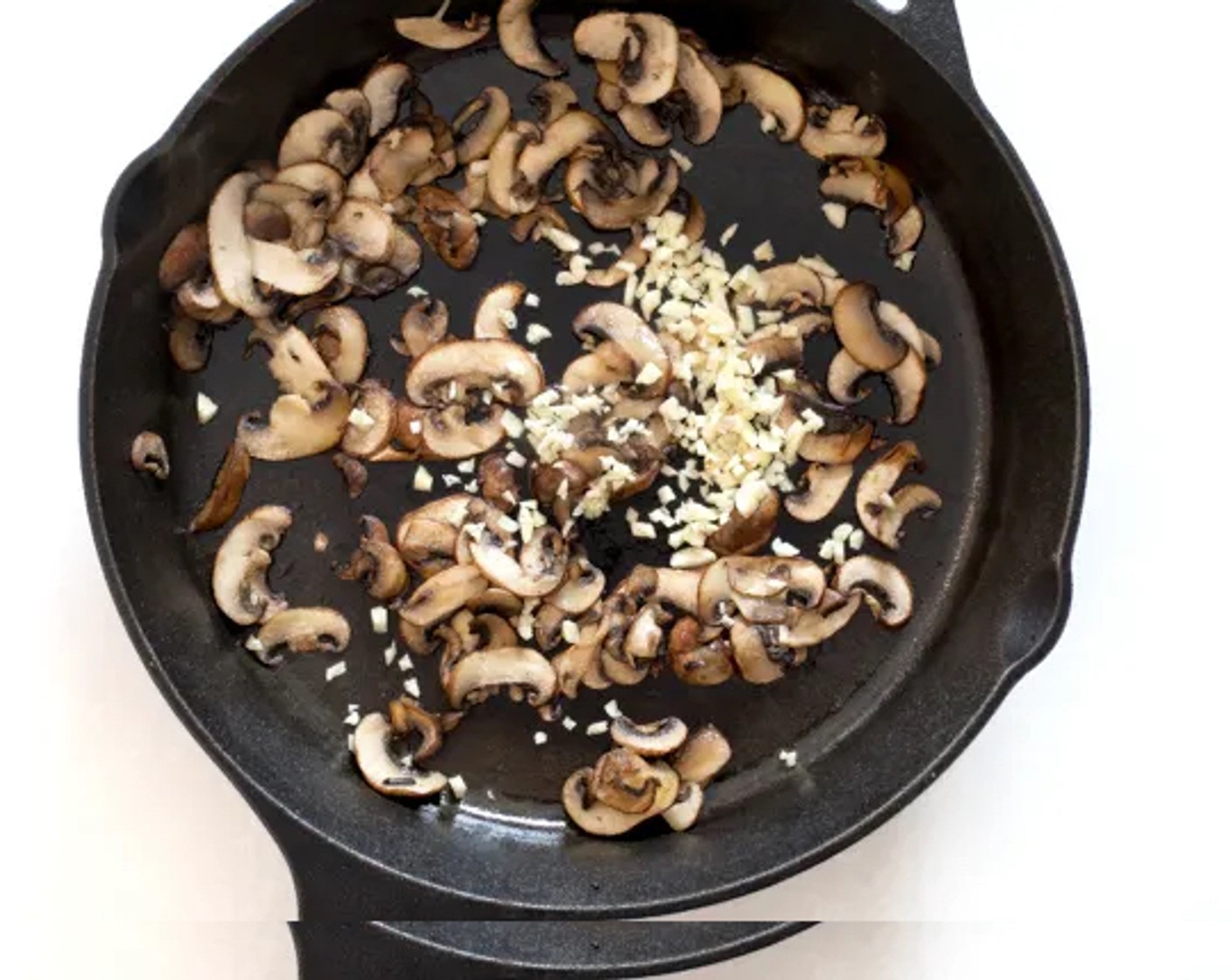 Schritt 2 In der Zwischenzeit in einem mittelgrossen Topf das Olivenöl (2 Esslöffel) erhitzen und die Champignons (115 g) 3 Minuten anbraten, bis sie weich und gebräunt sind. Knoblauch (4 Zehen) hinzugeben und 1 Minute kochen. Vom Herd nehmen.